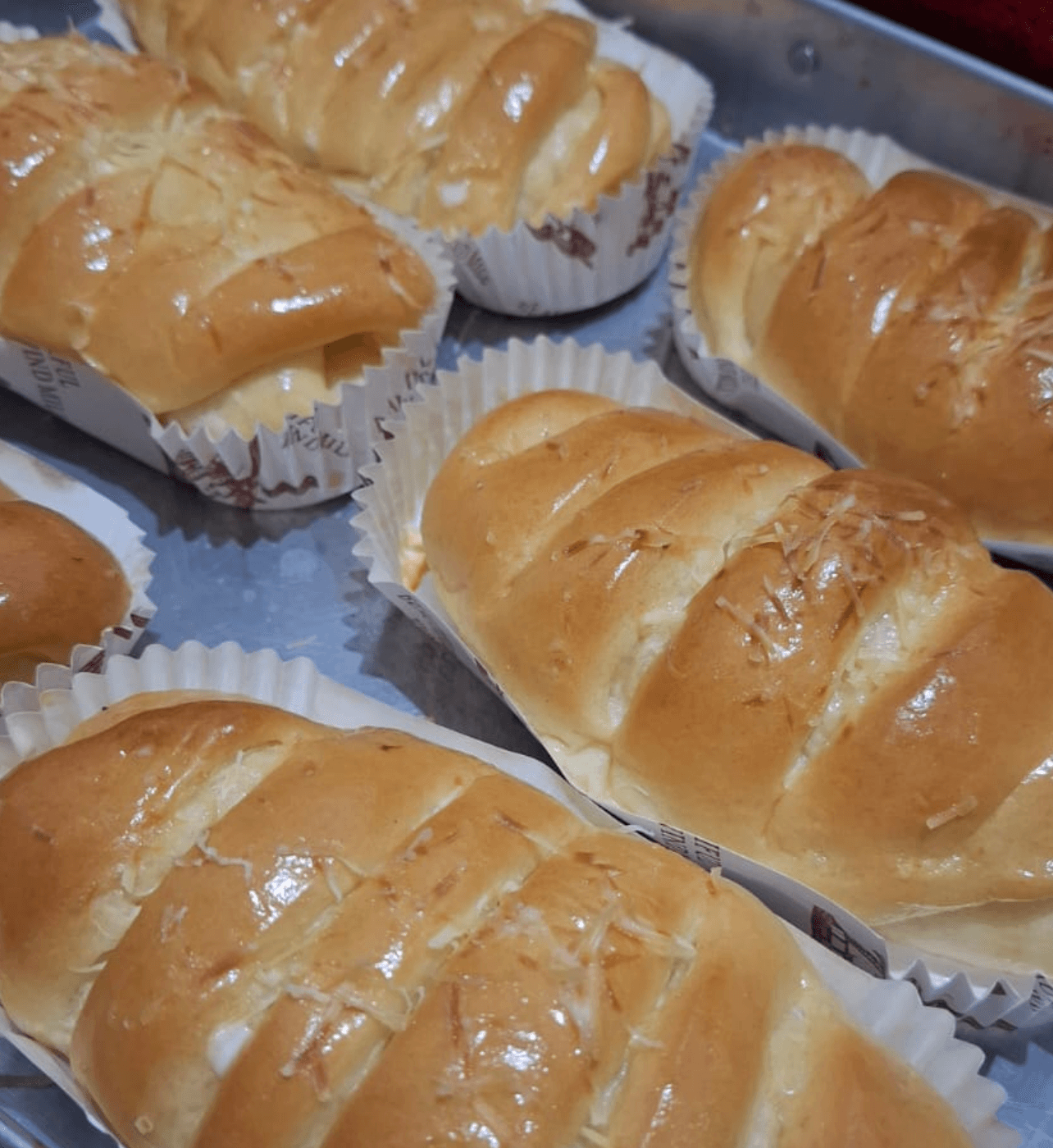 Roti lembut isi pisang bertabur keju di atas loyang