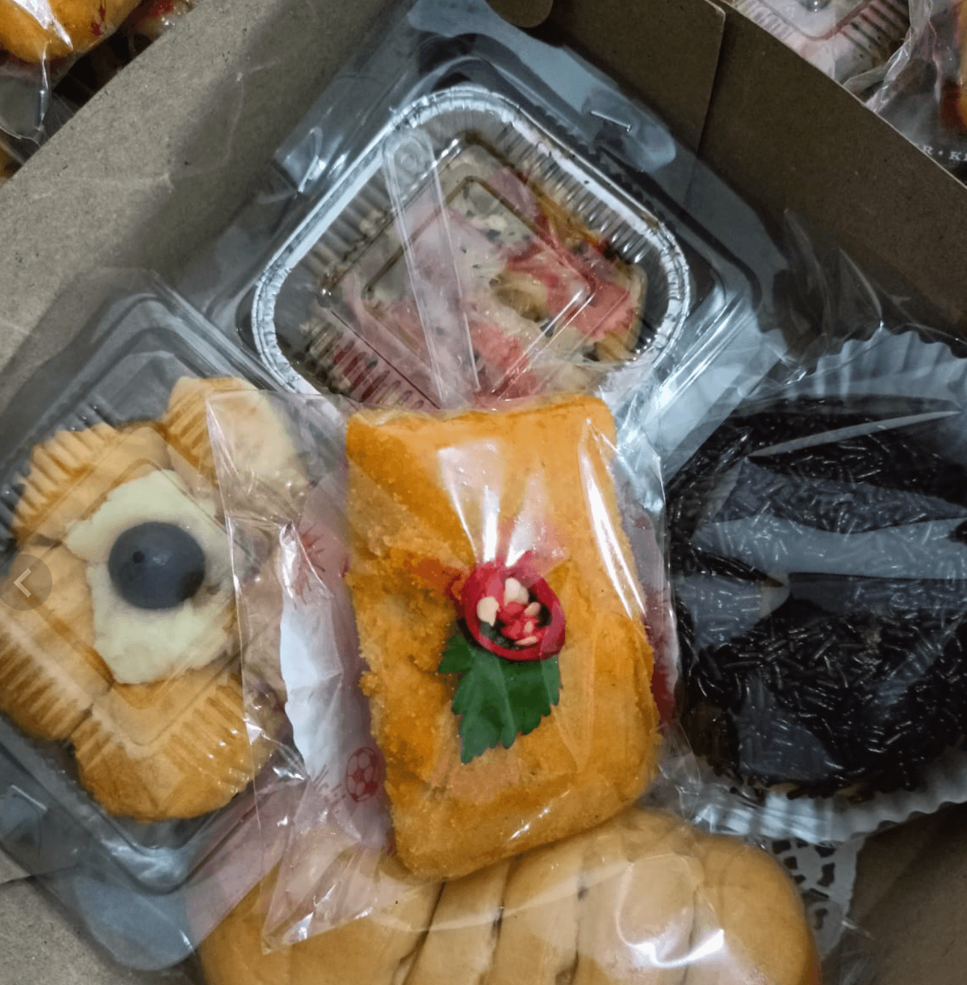 Kotak snack berisi aneka kue kering, risoles, dan roti untuk acara